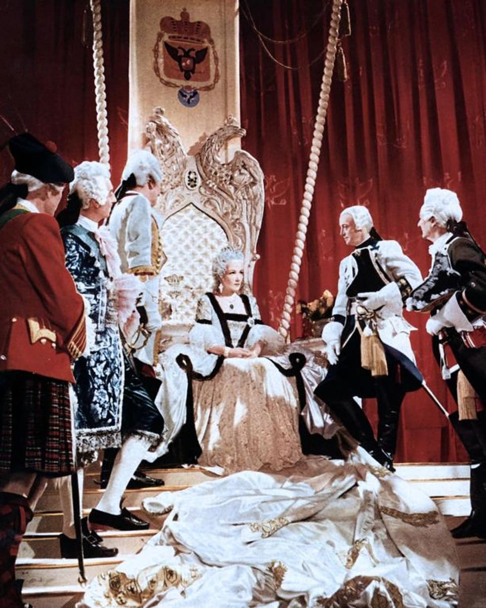 Brigitte Horney als Zarin Katharina II sitzt auf einem goldenen Thron, umgeben von ihrer Gefolgschaft.