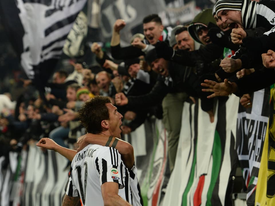 Feiernde Juventus-Fans und -Spieler nach einem Tor.
