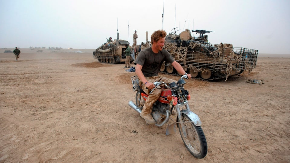 Prinz Harry sitzt auf einem verlassenen Motorrad.