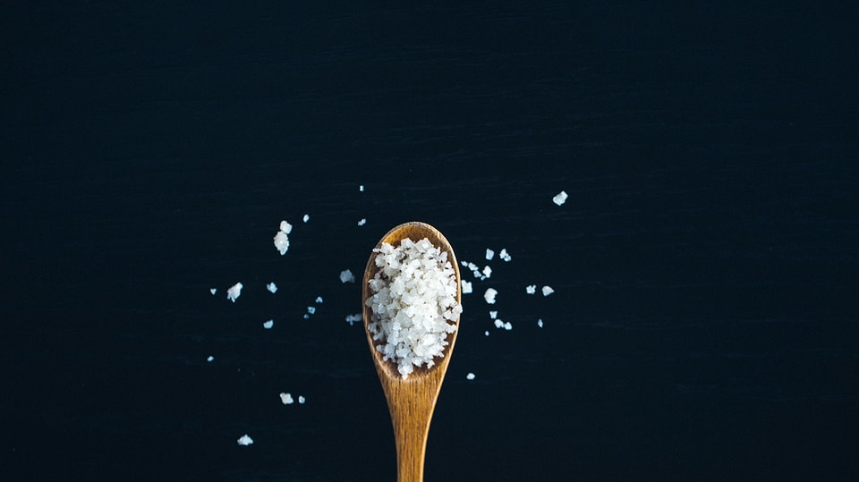 Ein Holzlöffel mit Salz. 