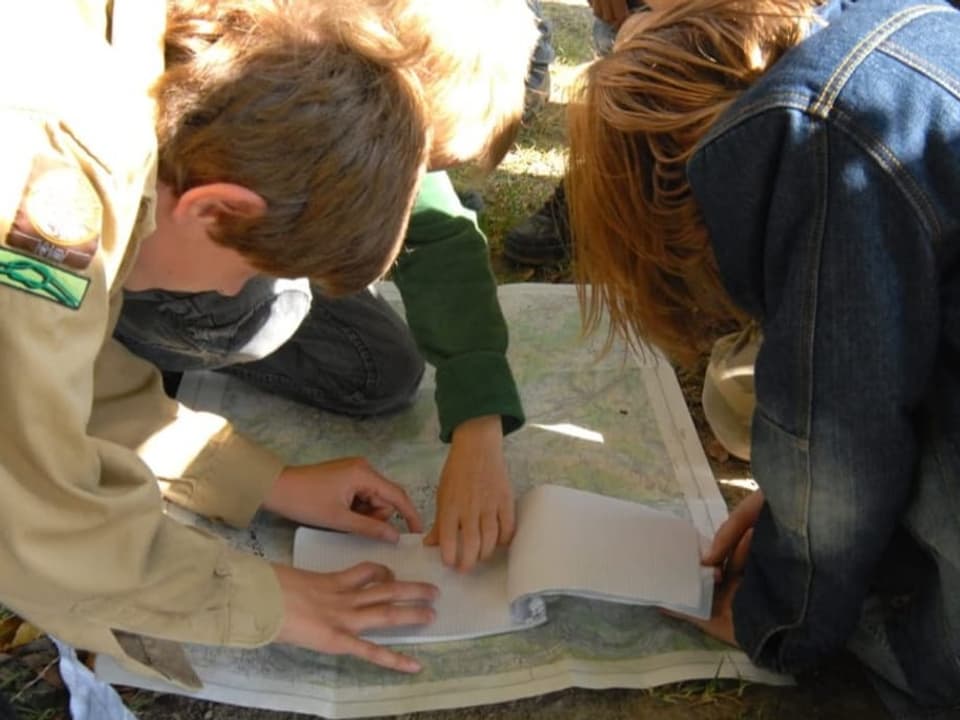 Pfadfinder-Kinder lesen eine Landkarte