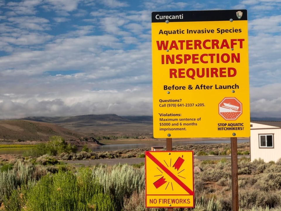 Ein gelbes Schild mit roter Schrift mit Vorschriften zu Wasserfahrzeug-Inspektionen.