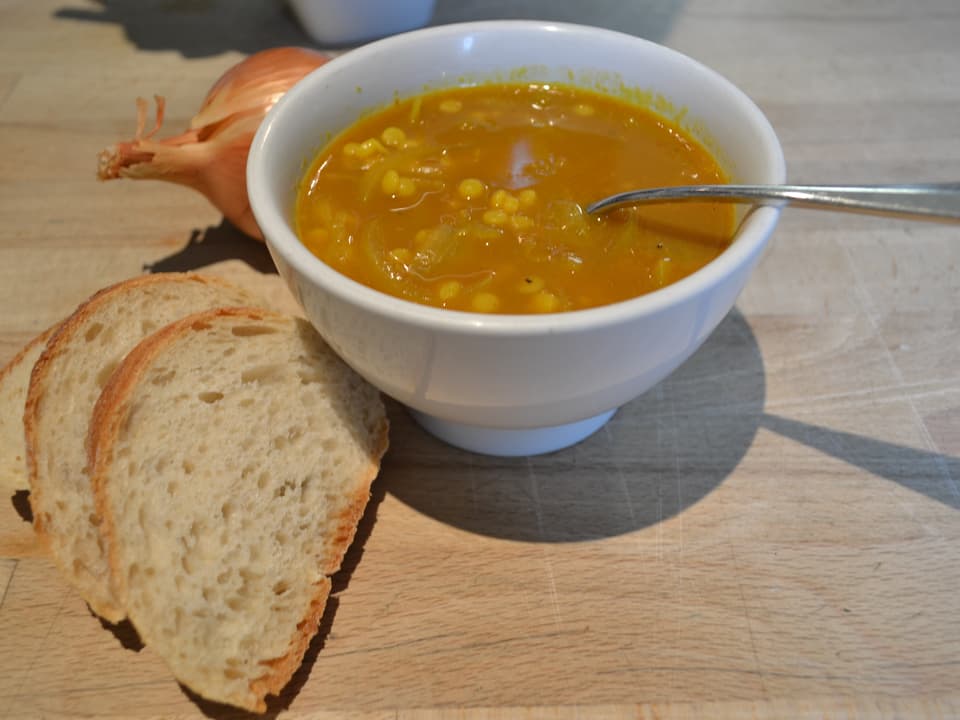 Eine Schale mit einer gelblichen Suppe 