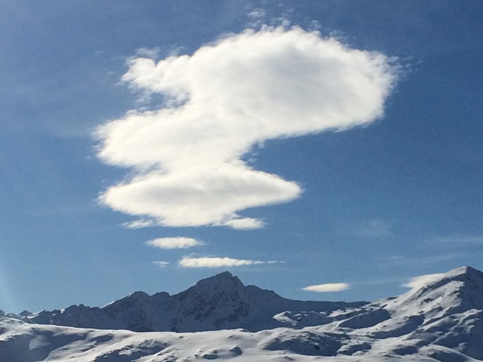 Kunstvolle Wolke über den Gipfeln Graubündens