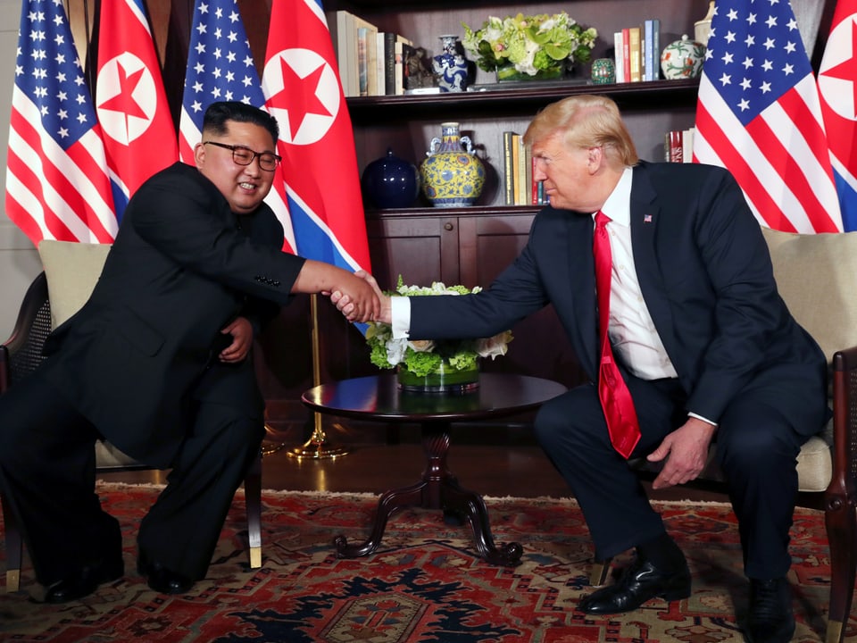 Kim und Trump geben sich die Hand.