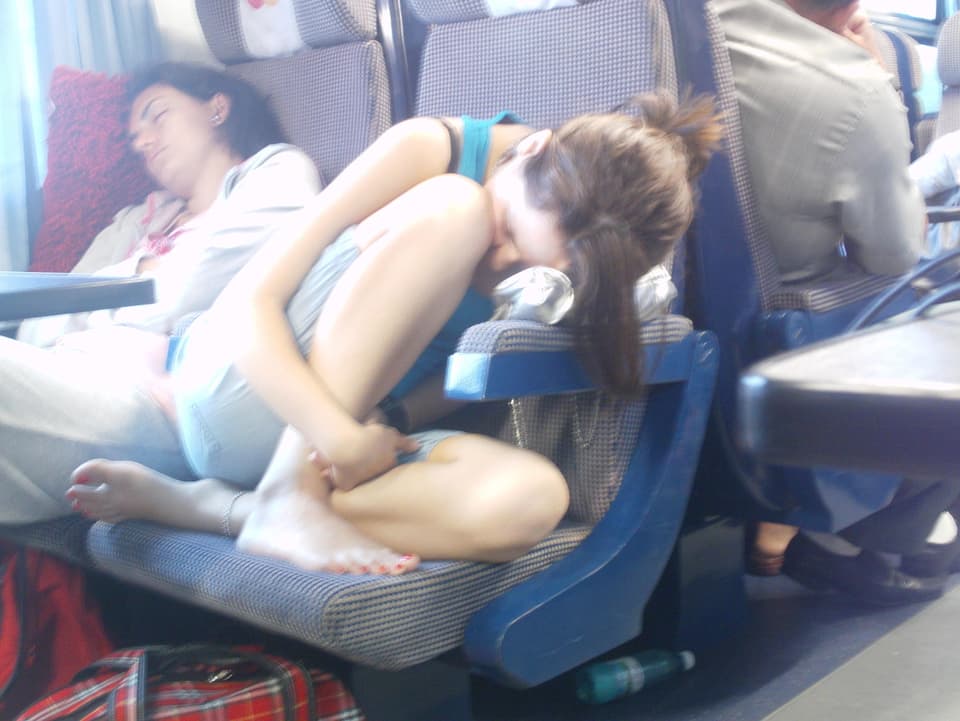 Eine junge Frau versucht während einer Zugfahrt zu schlafen.