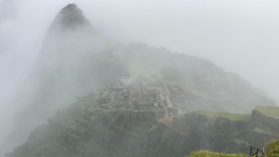 Inka-Ruinen erheben sich aus den Nebelschwaden.