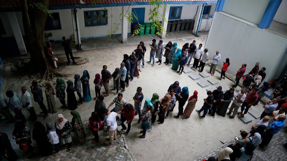 Wähler stehen Schlange bei einem Wahllokal