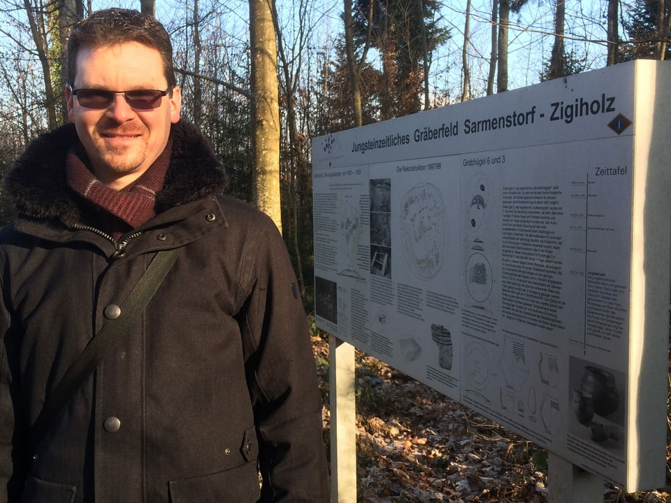 Archäologe Thomas Matter vor der veralteten Infotafel zu den Gräbern im Zigiholz.