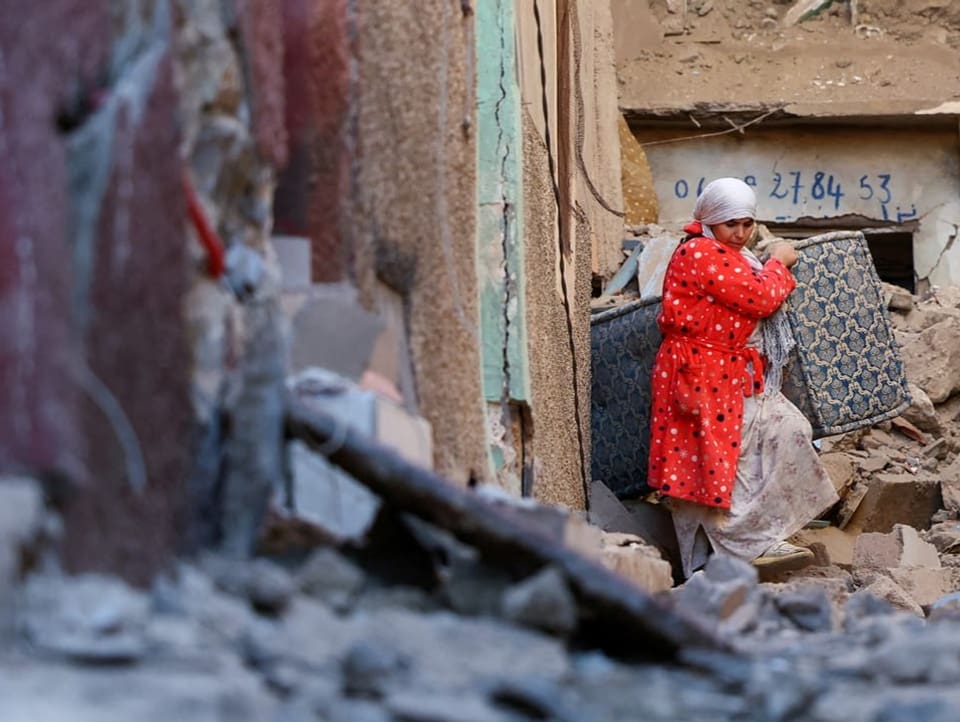 Eine Frau holt im Dorf Moulay Brahim ein paar Habseligkeiten aus ihrem zerstörten Haus.