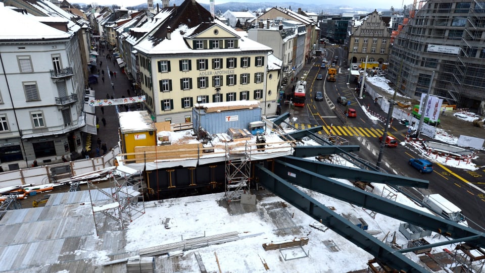 Ein weisses Haus, davor eine Baustelle mit sternförmigen ausgerichteten Stahlträgern.
