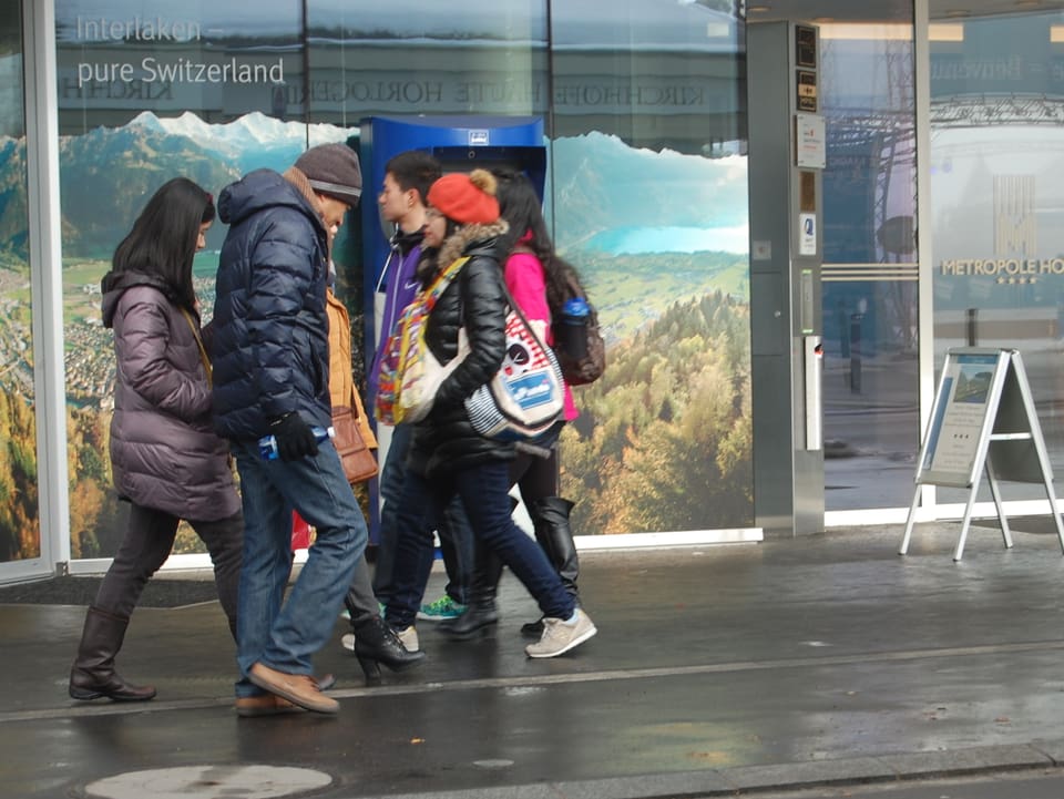 Asiatische Touristen bummeln durch Interlaken.