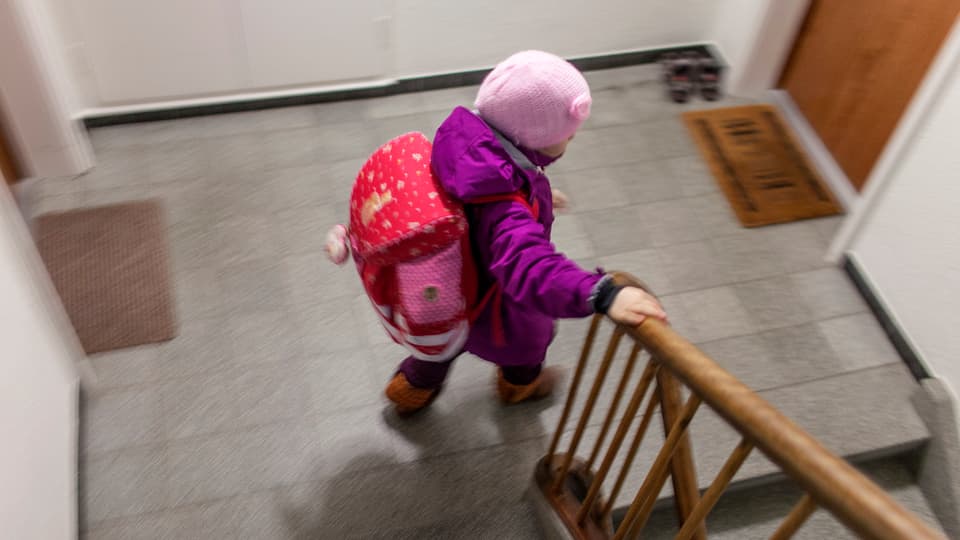 Ein Kind steigt ein Treppenhaus hinunter.