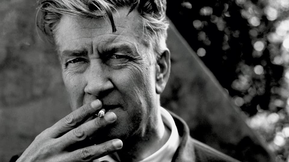 Porträt von David Lynch mit einer Zigarette im Mund.