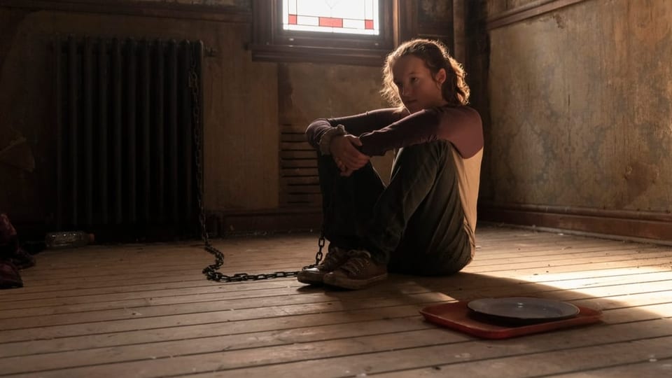 Bella Ramsey als Ellie sitzt angekettet in einem Raum auf dem Boden.