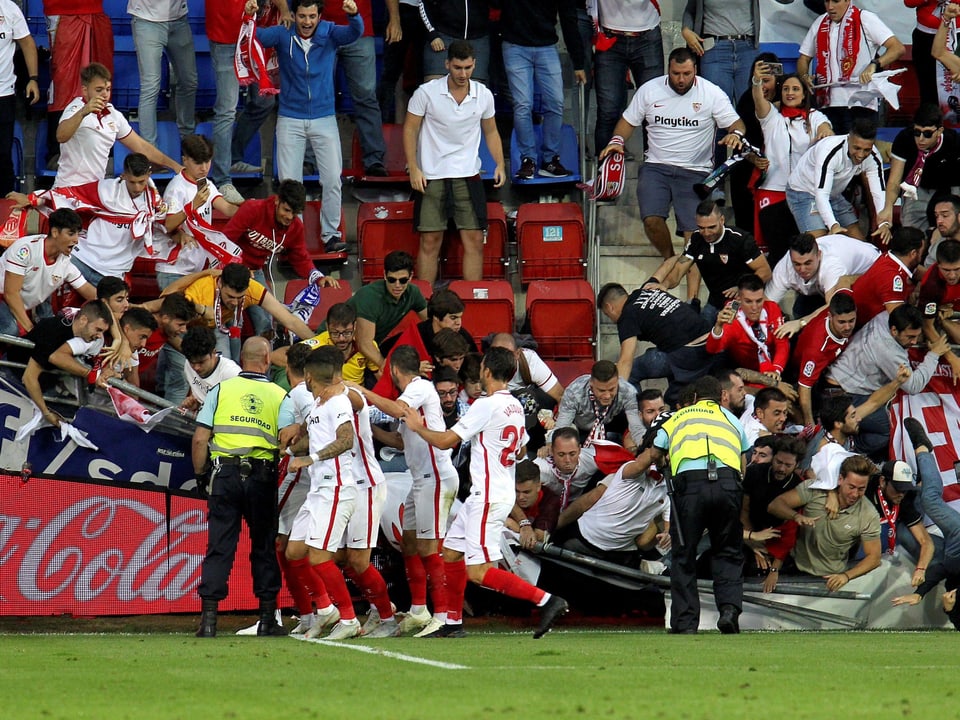 Während Sevilla-Spieler einen Treffer bejubeln stürzt im Gästefan-Block ein Geländerteil ein. 