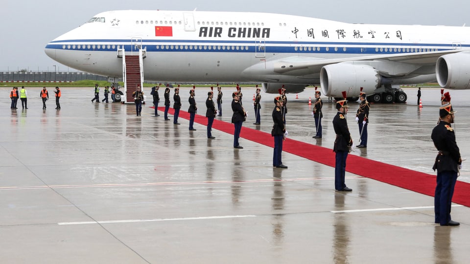 Air China Flugzeug neben Ehrenformation auf regnerischem Rollfeld in Frankreich.