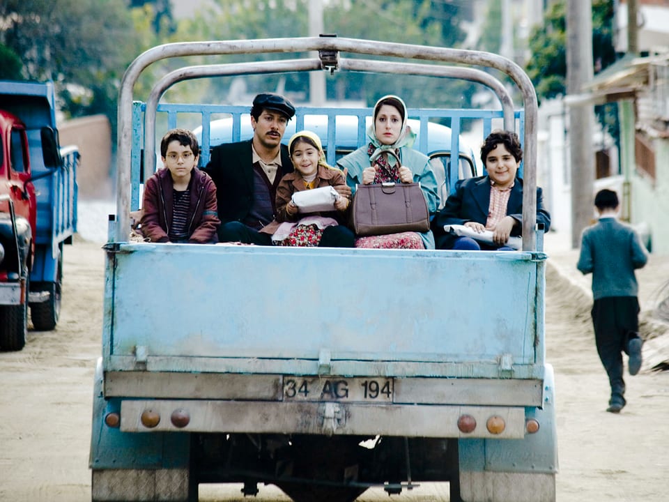 Das Bild zeigt die fünfköpfige türksiche Familie auf der Ladefläche eines Transporters.
