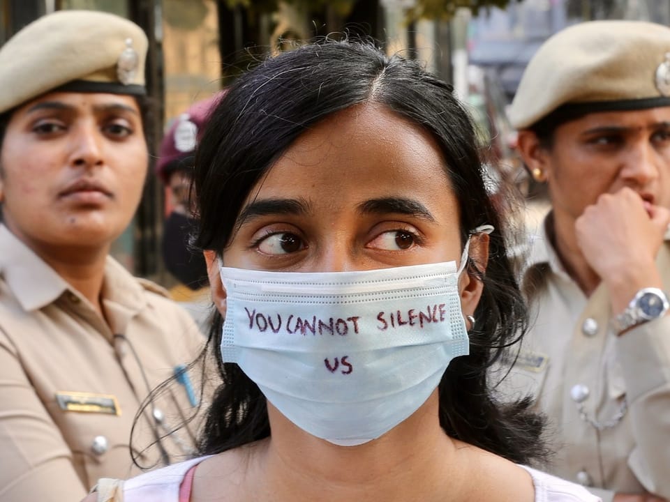 Eine Frau trägt eine Maske mit der Aufschrift «You Can Not Silence Us»