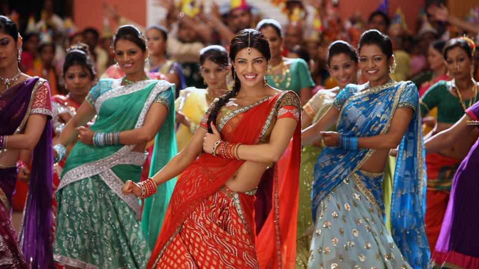 Frauen in traditionellen indischen Saris tanzen bei einer Feier.