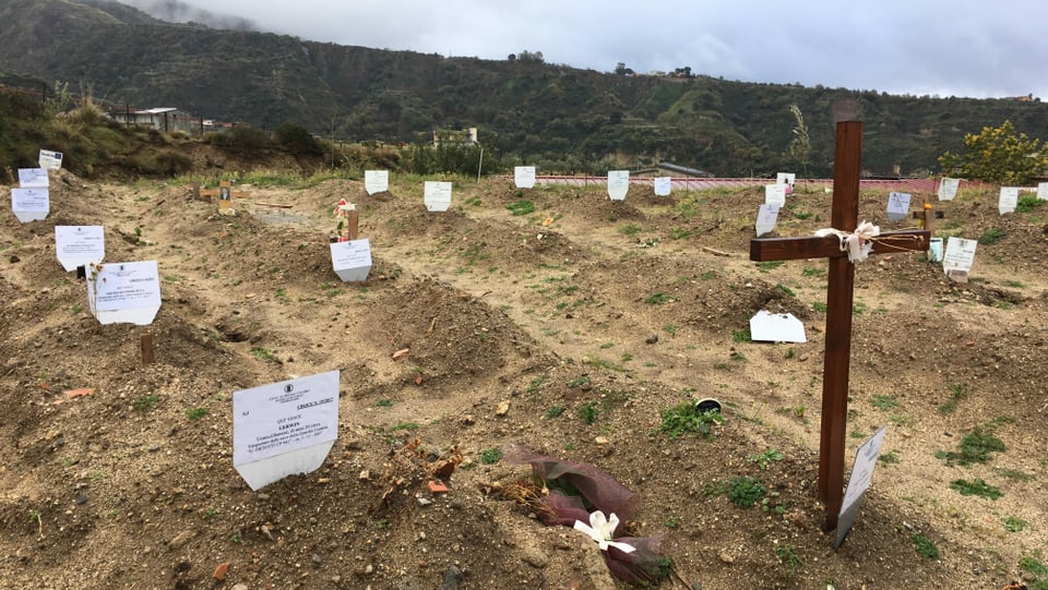 ein Feld mit einem Holzkreuz und einigen Namensschilder