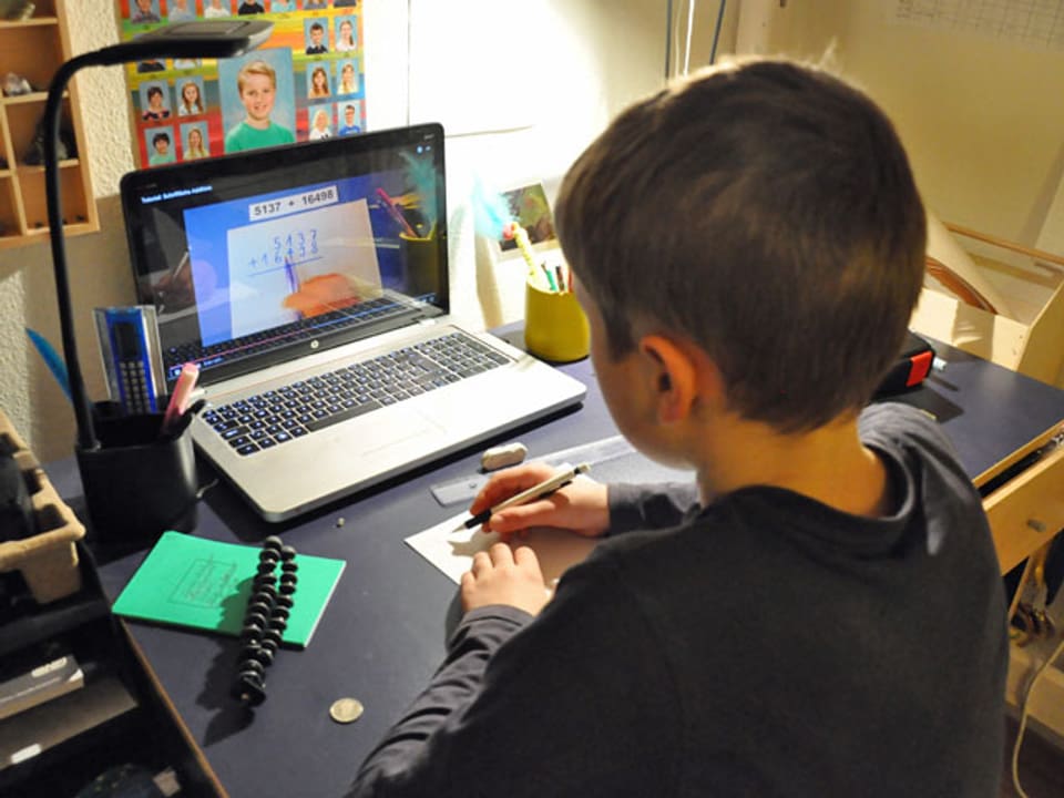 Schüler mit Laptop macht Hausaufgaben.