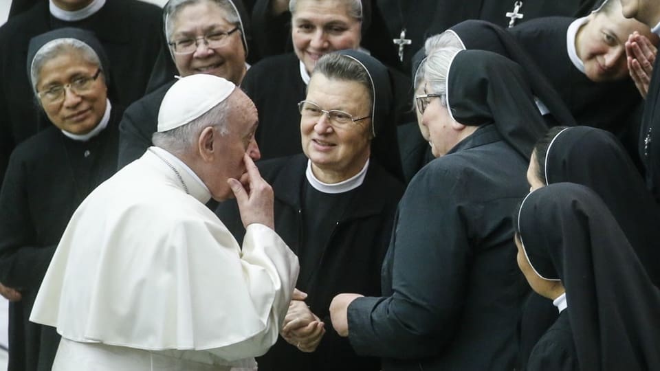 Papst Franziskus spricht mit mehreren Nonnen im Ordensgewand