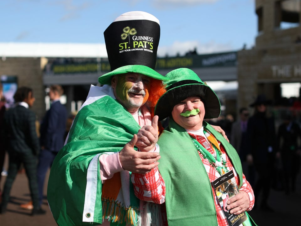 Ein Mann und eine Frau in grünen Kleidern feiern.