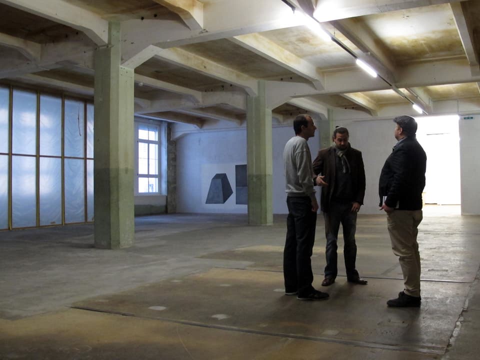 Drei Personen stehen in einem leeren Raum des Kulturzentrums Kammgarn.