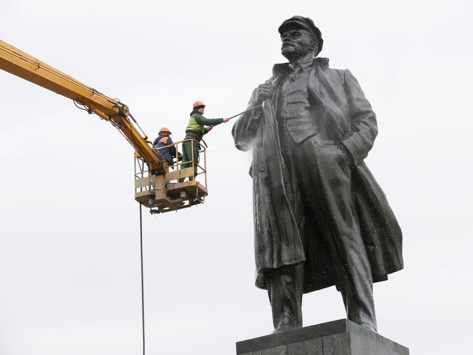 Arbeiter putzen eine gigantische Lenin-Statue