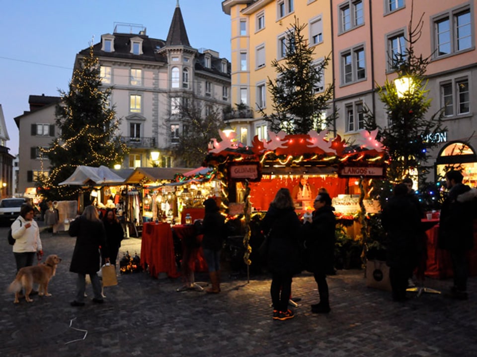 Beleuchtete Marktstände in der Abenddämmerung