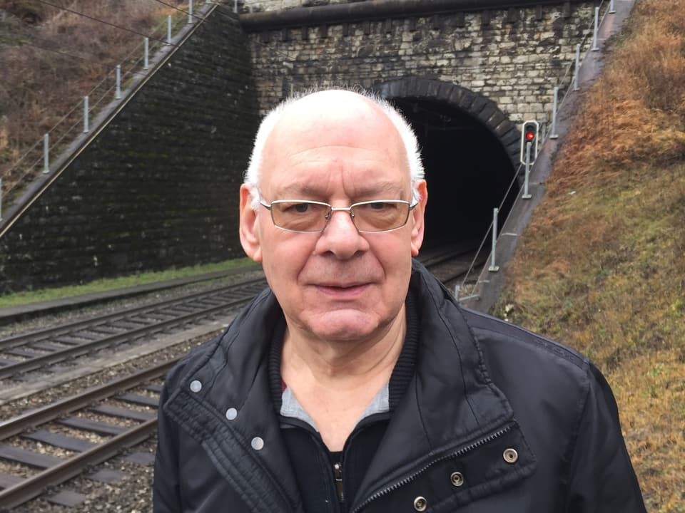 Älterer Mann mit weissem Haar an den Schläfen vor einem Tunneleingang