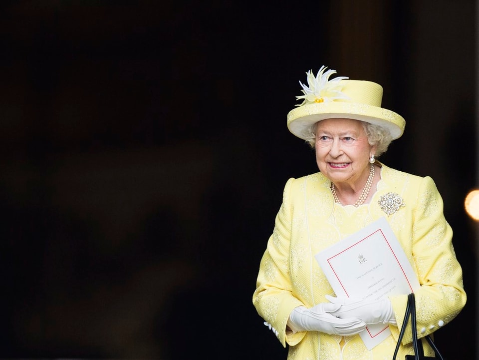 Die Queen mit Hut in einem gelben Kleid
