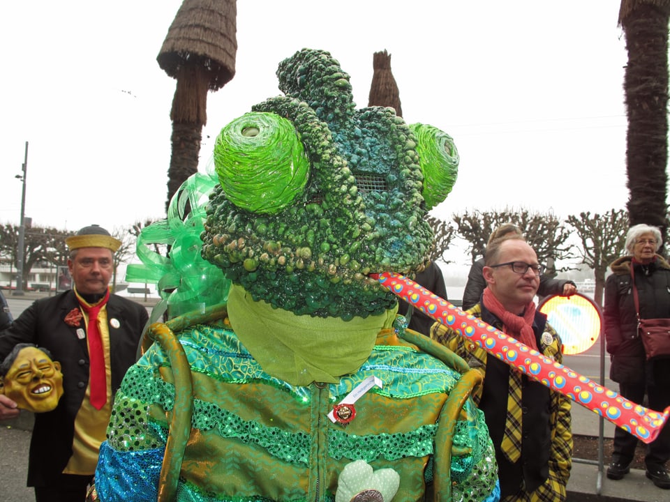 Fasnächtler an der Luzerner Fasnacht als grünes Monster verkleidet. 
