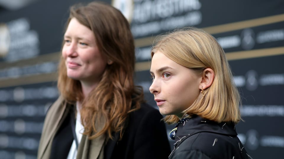 Eine junge und eine etwas ältere Frau vor deiner Wand mit der Aufschrift "Zurich Film Festival"