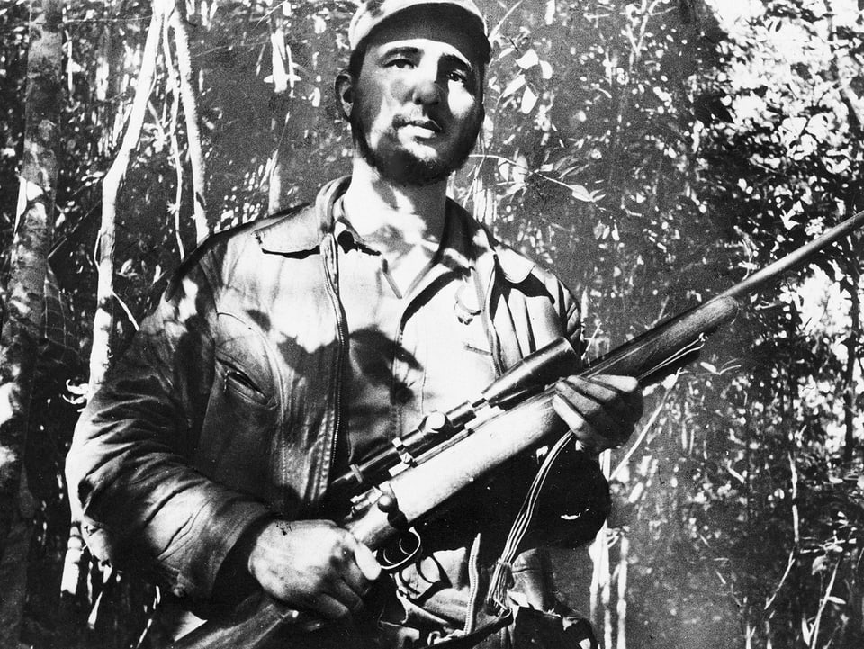 Junger Fidel Castro mit Gewehr in der Hand im Dschungel