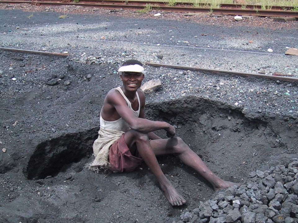 Ein Mann sitzt auf dem Boden einer Mine.