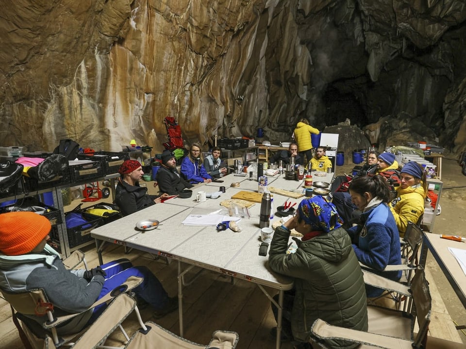 Teilnehmer der Experiments sitzen in der Höhle an einem Tisch.