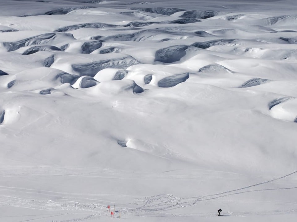 Ein Teilnehmer auf der Gletscherabfahrt, umgeben von Eisriesen.
