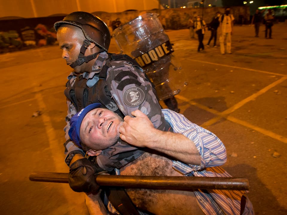 Ein Militärpolizist nimmt einen Demonstranten in den Würgegriff.