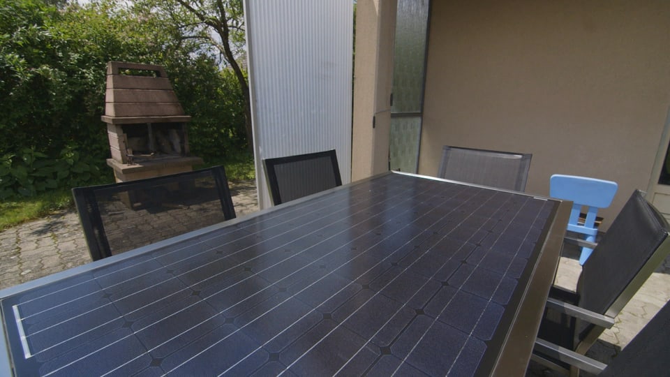 Ein Tisch mit Solarpanels auf einer Terrasse. 