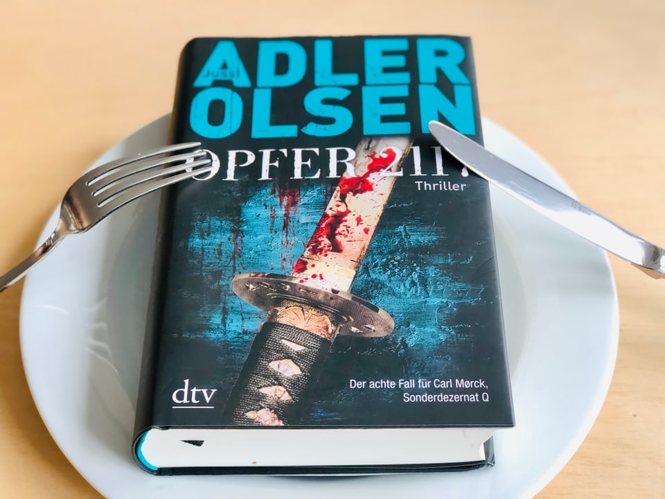 Jussi Adler-Olsens neuer Thriller «Opfer 2117» liegt auf einem weissen Teller.