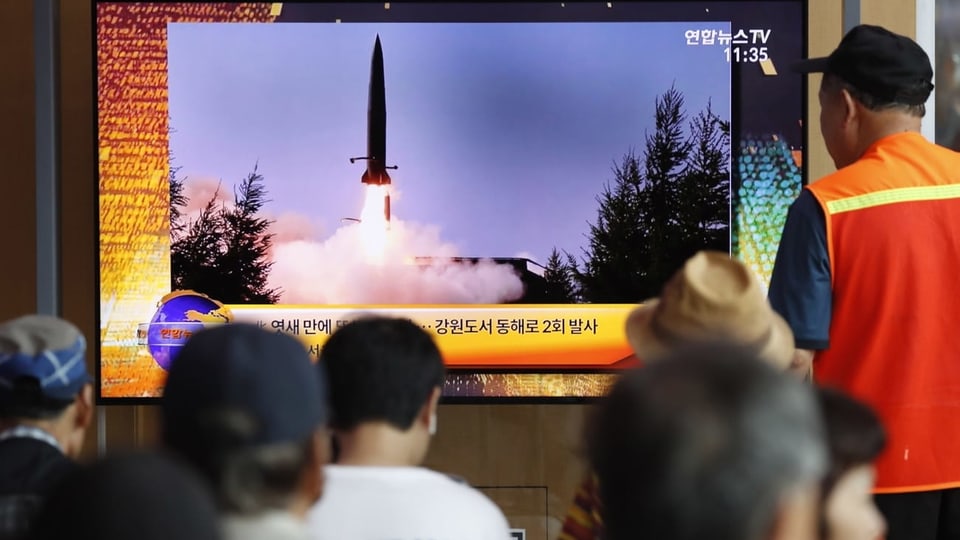 Südkoreaner schauen auf Bildschirm mit Raketentest