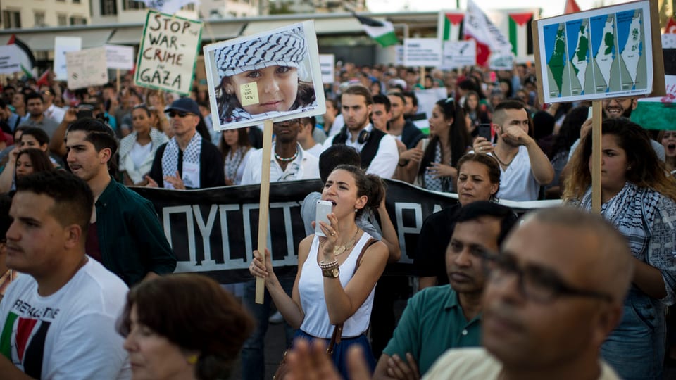 Menschen auf der Strasse, demonstrierend gegen Beschuss von Gaza.