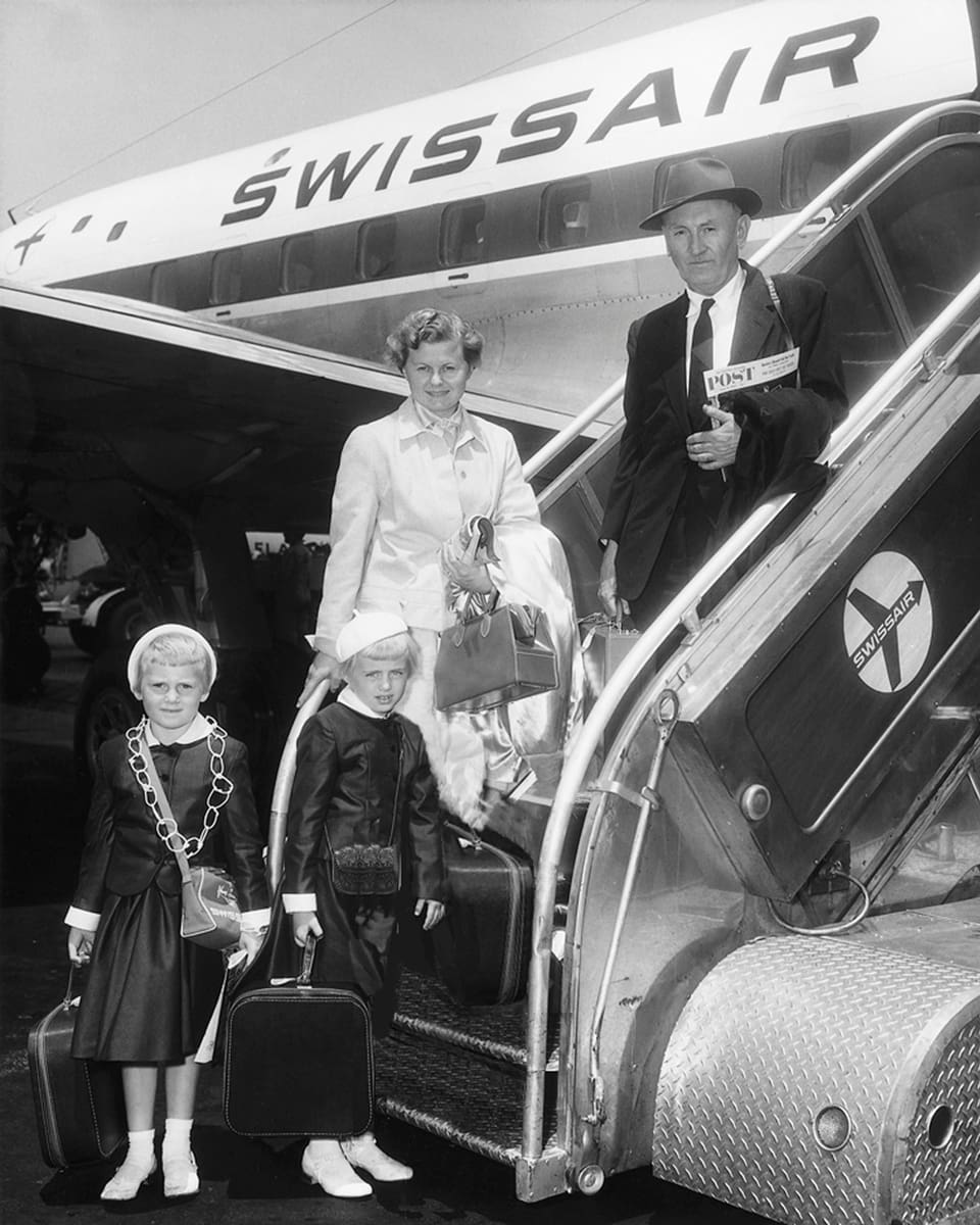 Ein Swissair-Flugzeug. Auf der Treppe steht Fritz Zwicky mit einer Frau und zwei Mädchen.