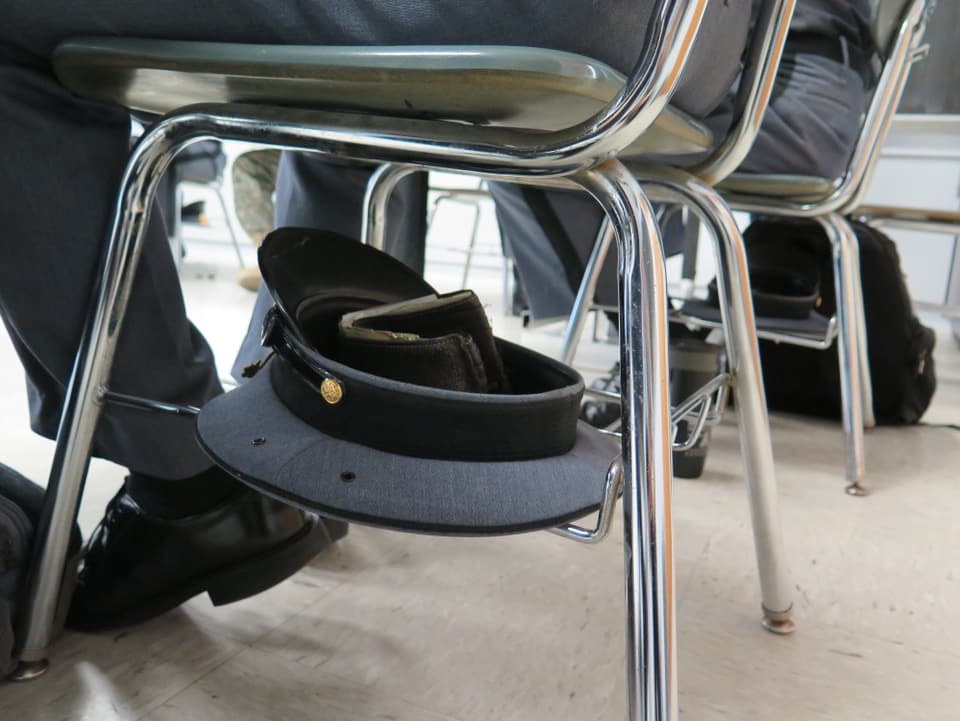 Stuhl mit Ablagefläche für den Hut unter der Sitzfläche.