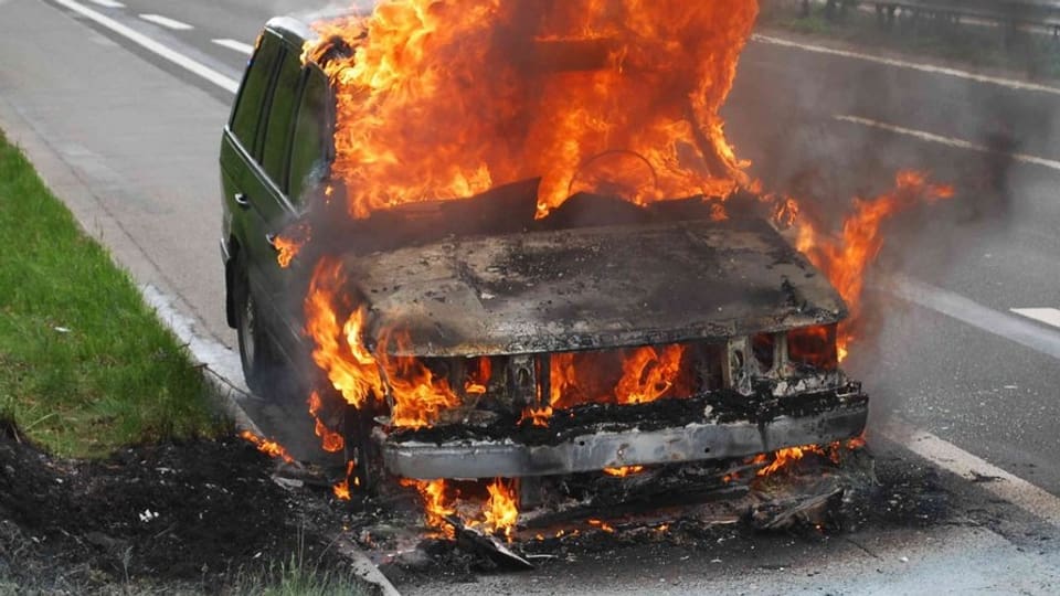 Brennendes Auto auf der Autobahn.