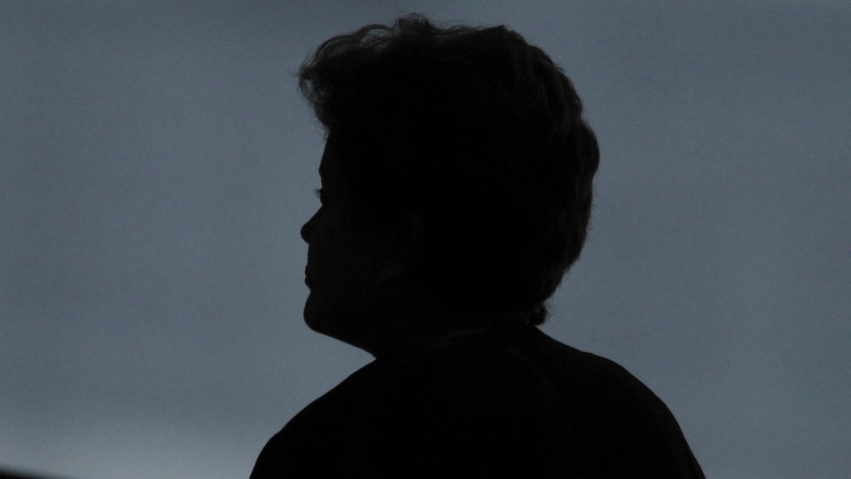 Kopf einer Frau als Silhouette vor dunklem Hintergrund