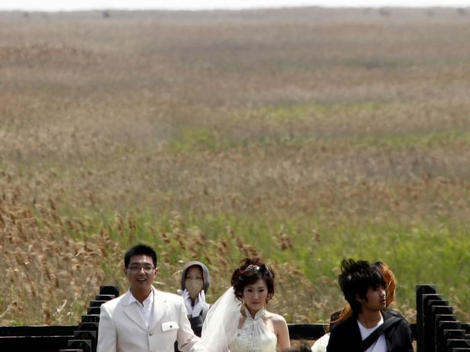 Ein chinesisches Hochzeitspaar posiert vor der Kamera.