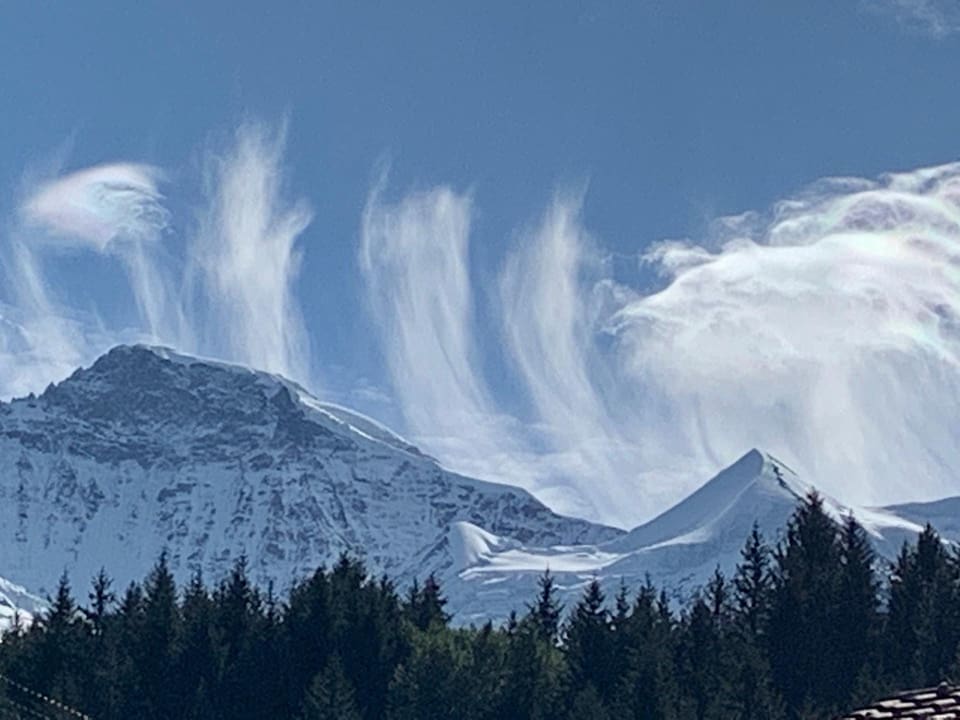 Dünne Wolken, wie Fäden, ziehen über die Berner Alpen.